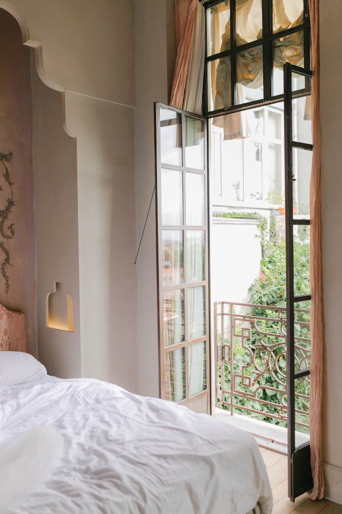 Inviting bedroom with open balcony, soft bedding, and elegant decor in İstanbul.